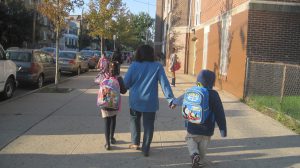 Adult walking two children to school
