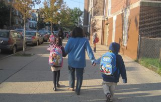 Adult walking two children to school