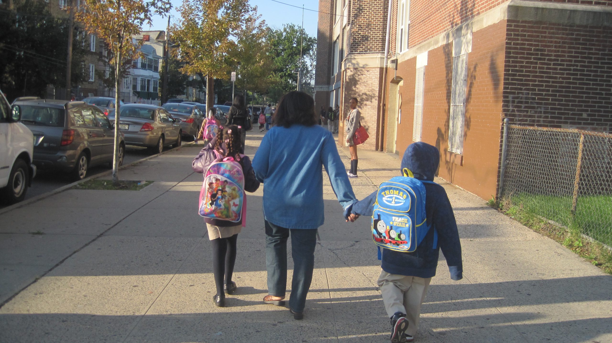 Adult walking two children to school